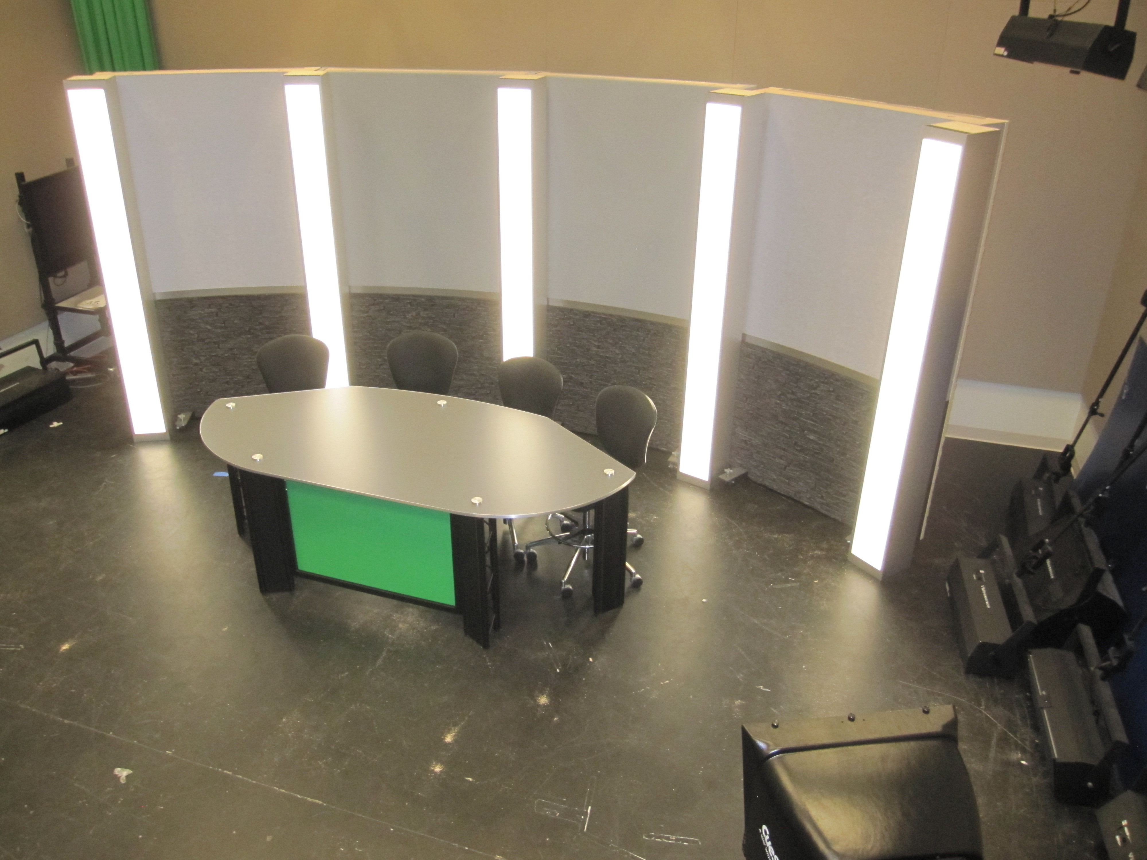 News desk for 4 - 5 talent with stone and grey set background and led light box columns